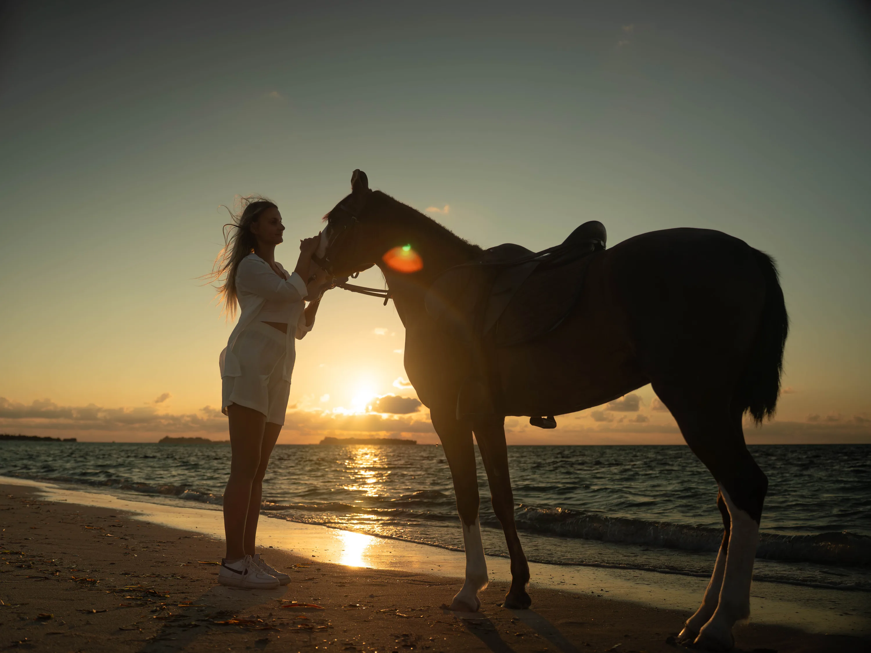 A couple dancing on the sand at dusk