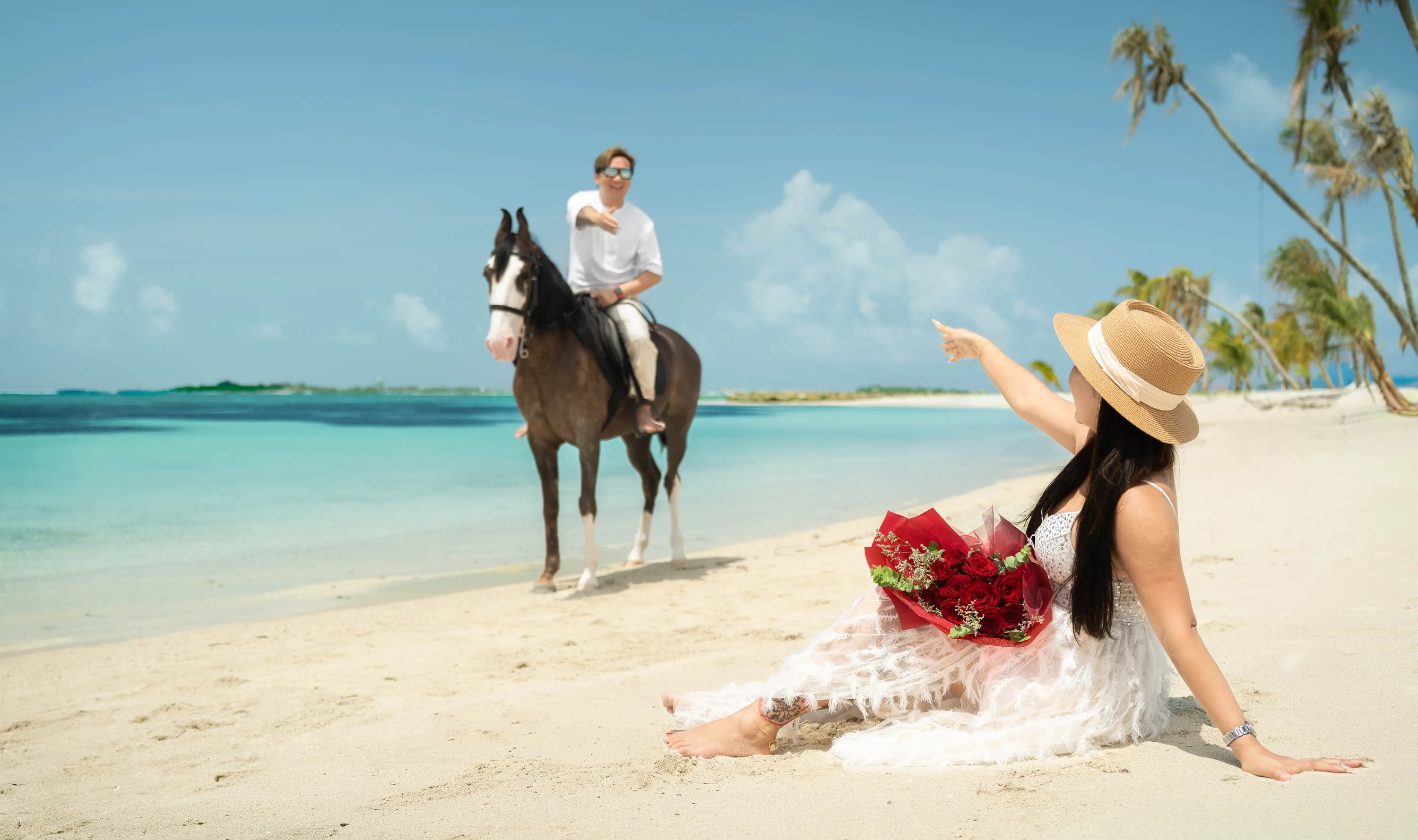 A rider on the beach and a guest with roses under the palms